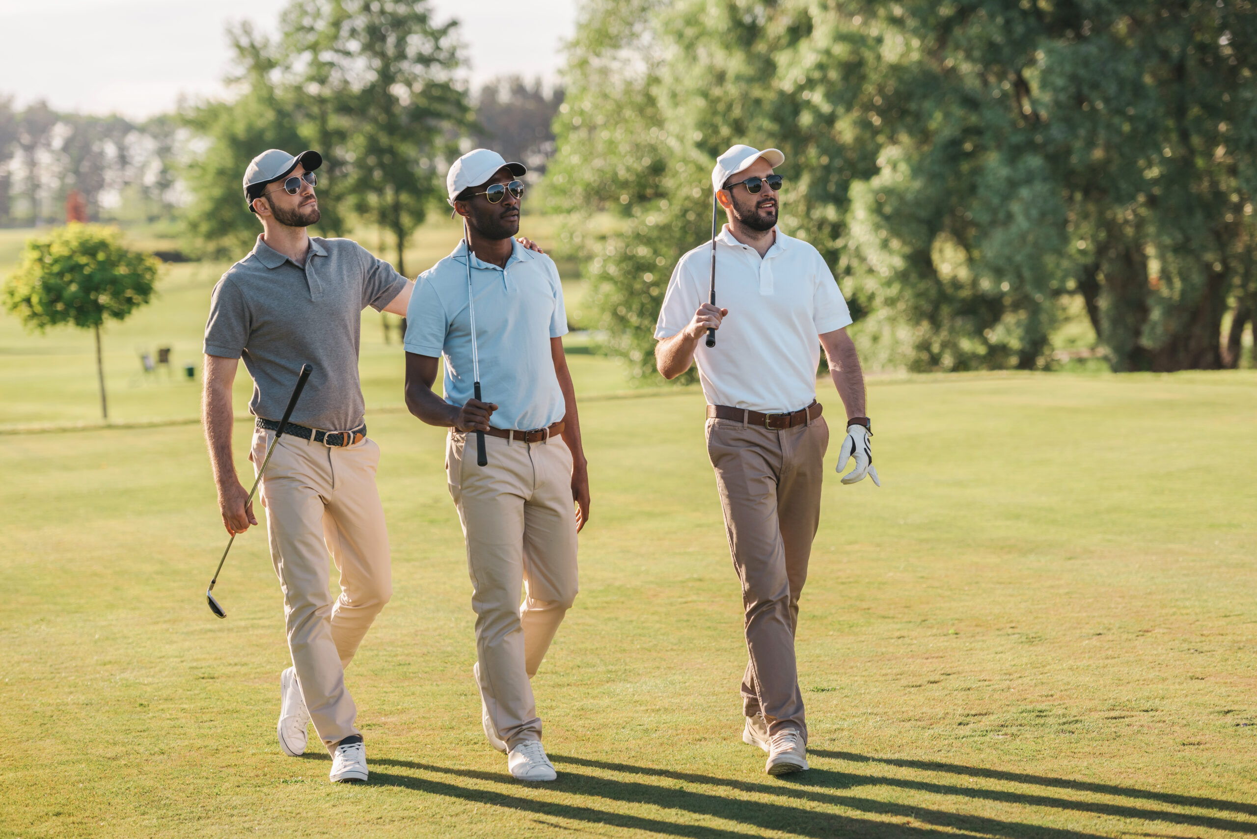 Three smiling friends on the golf course