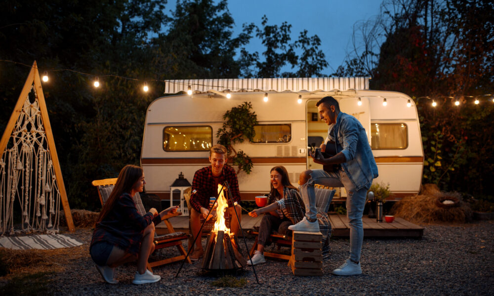 Friends warming themselves by the bonfire, camping