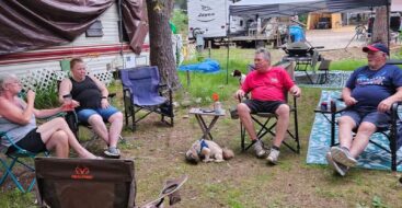 family gathered at their campsite sitting in a line