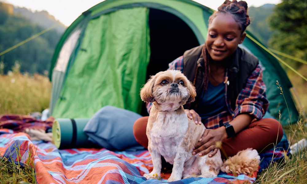 woman and her dog camping in nature